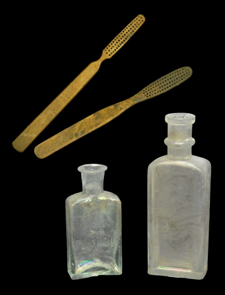 Two bone-handled toothbrushes (Cat # 4.31.98 and 4.24.538). (Left) Bottle embossed “R. B. Da Costa” “West Indian Toothwash” (4A-G-0081). (Right) Paneled bottle marked “Van Buskirk’s Fragrant Sozodont” (4A-G-0064). 