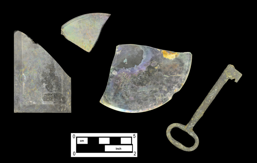 Three fragments of flat glass with beveled edges (Cat # 4.24.492, 4.24.606, 4.27.141) and brass “door key.”