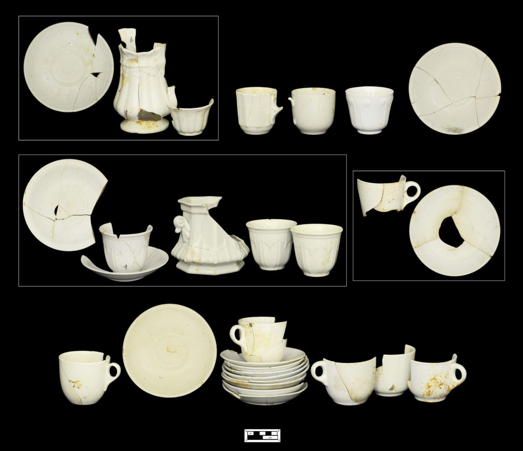 Plain and molded white granite tea ware: (Top row, left to right) Saucer, creamer, and handless cup in Ceres pattern (4A-C-0011; 4A-C-0096; 4A-C-0095); three tea cups (4A-C-0015; 4A-C-0010; 4A-C-0036); saucer (4A-C-0081). (Middle row, left to right) Six pieces in Sydenham pattern, including saucer (4A-C-0094); cup and saucer (4A-C-0115; 4A-C-0021); sugar dish (4A-C-0098); two handless cups (4A-C-0025; 4A-C-0093); matching cup and saucer in Berlin Swirl pattern (4A-C-0090; 4A-C-0037). (Bottom row, left to right) Handled cup (4A-C-0016); saucer (4A-C-0008); unmatched stack of plain saucers (top to bottom: 4A-C-0019; 4A-C-0085; 4A-C-0077; 4A-C-0078; 4A-C-0022; 4A-C-0009; 4A-C-0079; 4A-C-0073); four handled cups (4A-C-0089; 4A-C-0088; 4A-C-0092; 4A-C-0109).
