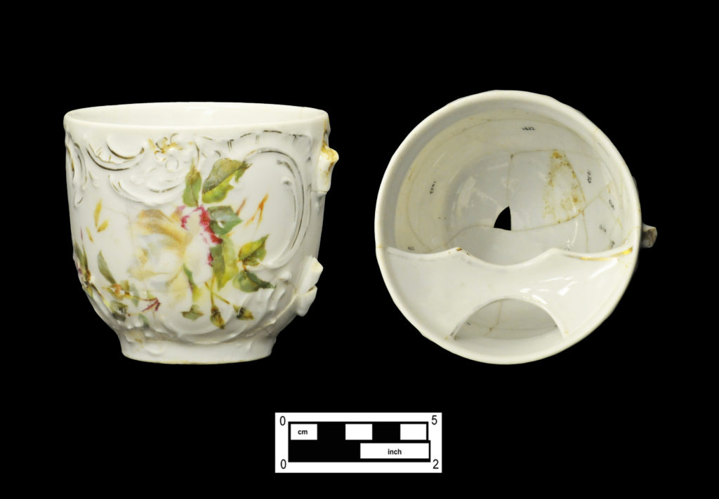 Two views showing mustache cup, decal-decorated over molded floral scrolls with gilt highlights (4A-C-0029).