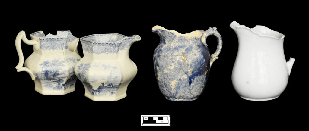 Four pitchers: Matched pair of hexagonal whiteware pitchers with blue printed romantic landscape scene (4A-C-0114; 4A-C-0112); blue Rockingham pitcher with molded shell and scroll motif at rim and handle (4A-C-0024); white granite pitcher with wide molded scalloped rim (4A-C0014).