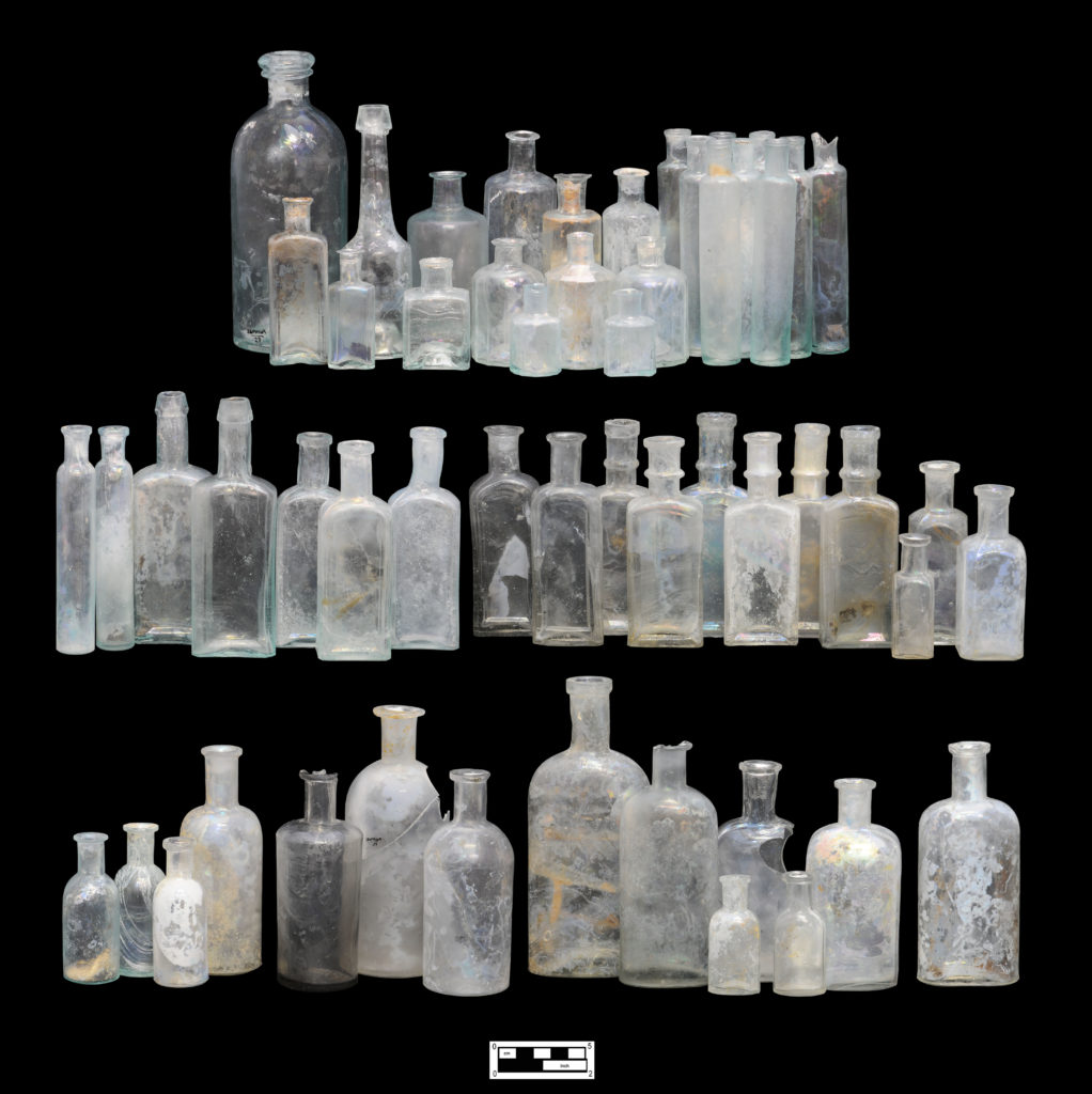 Shown here are examples of the more complete, unembossed bottles recovered from the Cramp-Bumm privy behind 1018 Palmer Street. At top are the earliest examples, all dating from the 1850s to mid-1860s. The majority of these earliest bottles feature blowpipe (“open”) pontil-scarred bases, with most blown in two-piece “hinge” molds. The remaining bottles include “hinge” molded examples (without pontil scars) and a small number featuring post-molded bases (center left), as well as a large number of cup-bottom molded bottles in a variety of forms, including rectangular and square (center right), round (bottom left), and oval (bottom right). Of dating significance is that NONE of these bottles bear air venting marks, a characteristic that became an industry standard by the early 1890s. The entire assemblage shown thus dates from the 1850s to ca. 1890. As noted, the production dates for all of these bottles then correspond to the Cramp family (1852-1889) occupation of 1018 Palmer Street. The bottle at bottom far right represents the bottle with the latest TPQ from this assemblage, dating from ca. 1876 to about 1890, and is a form known as the “Philadelphia Oval.” 